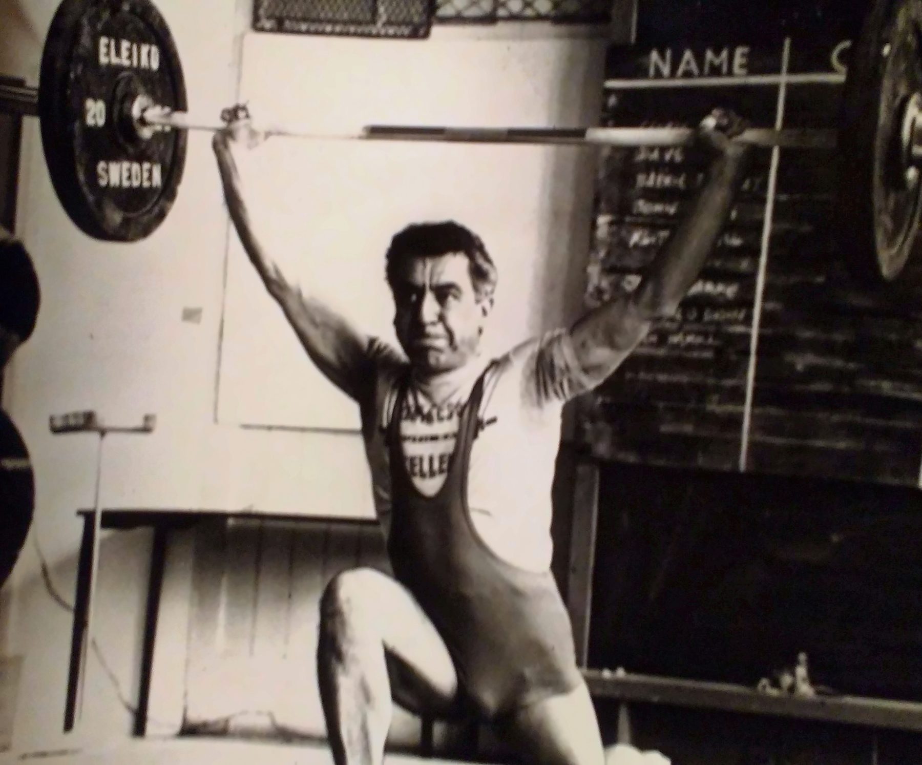 A young Brian holding a barbell overhead